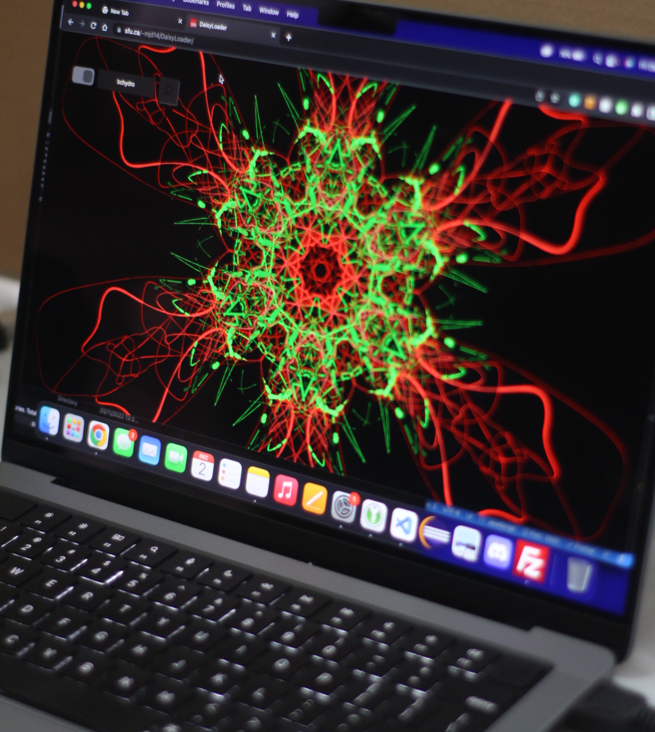 Laptop showing a vibrant green and red kaleidoscope