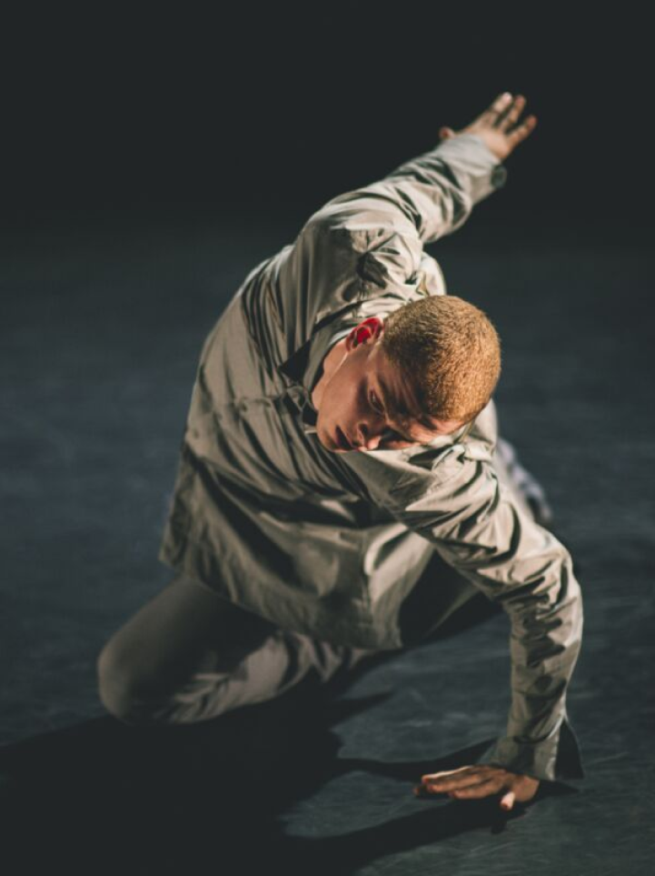 Dancer sprawled across the floor with dramatic lighting